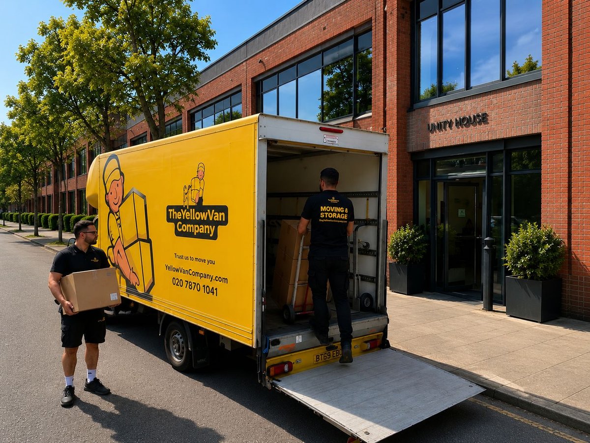 Yellow Van Company team loading office furniture onto a trolley and into a branded yellow van outside a London office building &mdash; family-run office removals across London since 2011